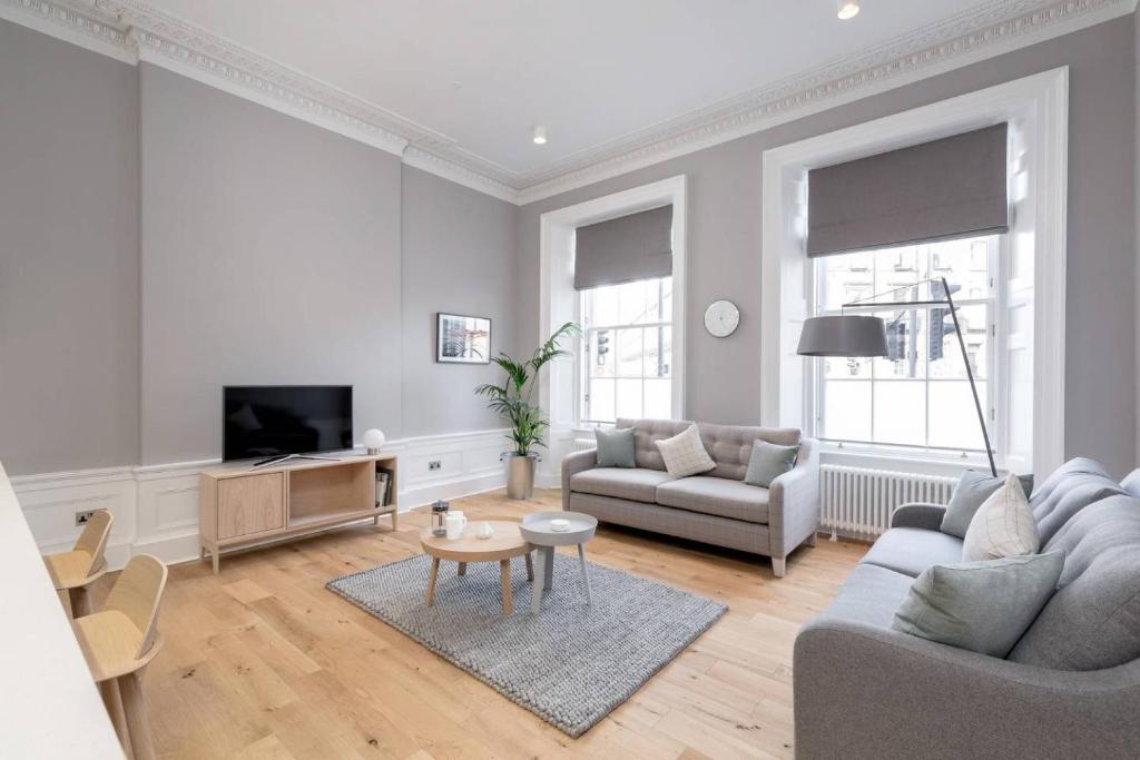a living room with a couch and a tv at ALTIDO Spacious and Bright 1bed Apt, short walk from Princes street in Edinburgh