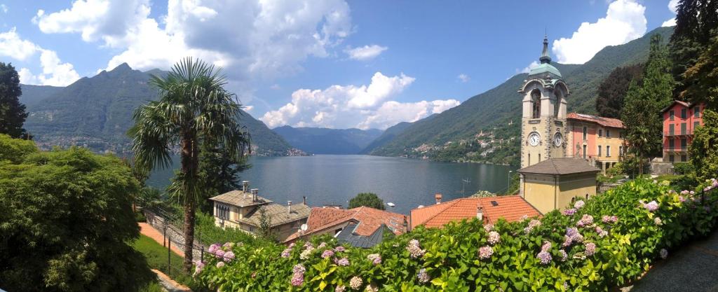 vistas a un lago y a un edificio con una torre del reloj en Riva di Faggeto Lario, en Faggeto Lario 