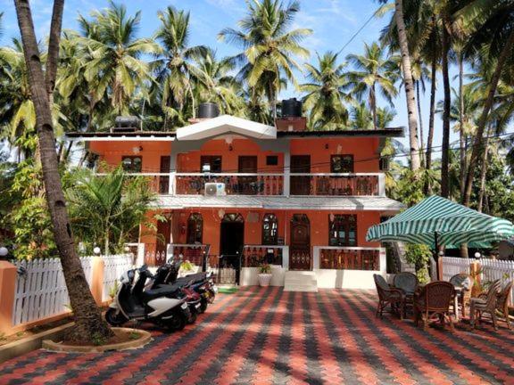 a house with a motorcycle parked in front of it at Hilias Retreat in Palolem