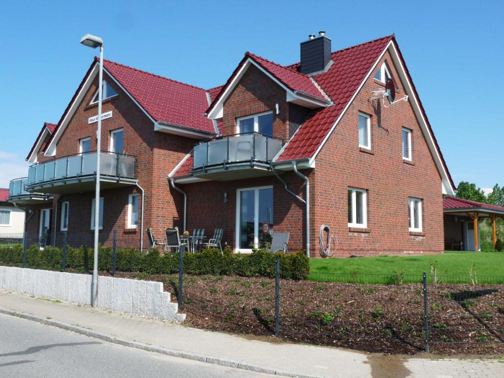 a brown brick house with a red roof at Wohnung Albatros im Haus Wassermann in Neu Gaarz