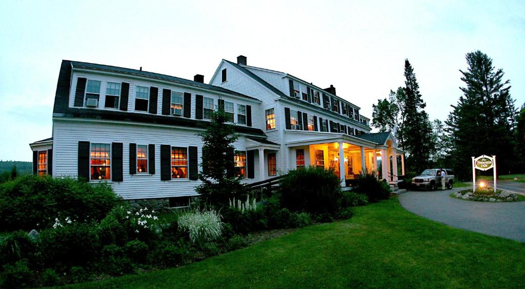 a large white house with a car parked in the driveway at Franconia Inn in Franconia