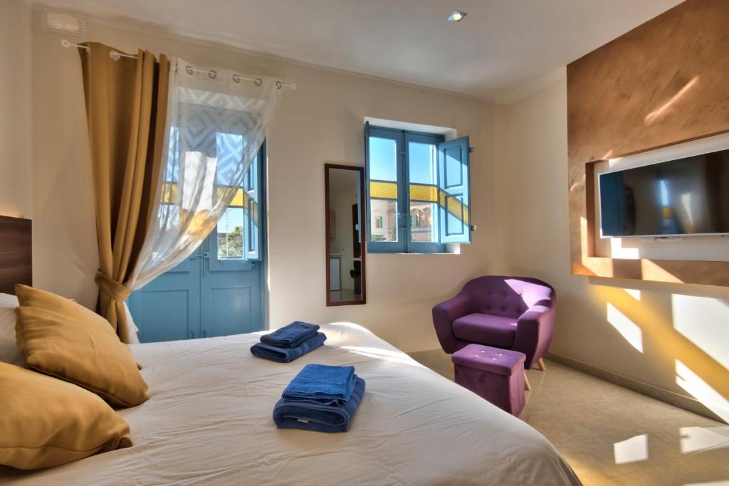 ein Schlafzimmer mit einem Bett mit zwei blauen Handtüchern darauf in der Unterkunft Central Suites St. Julian's in St Julian's