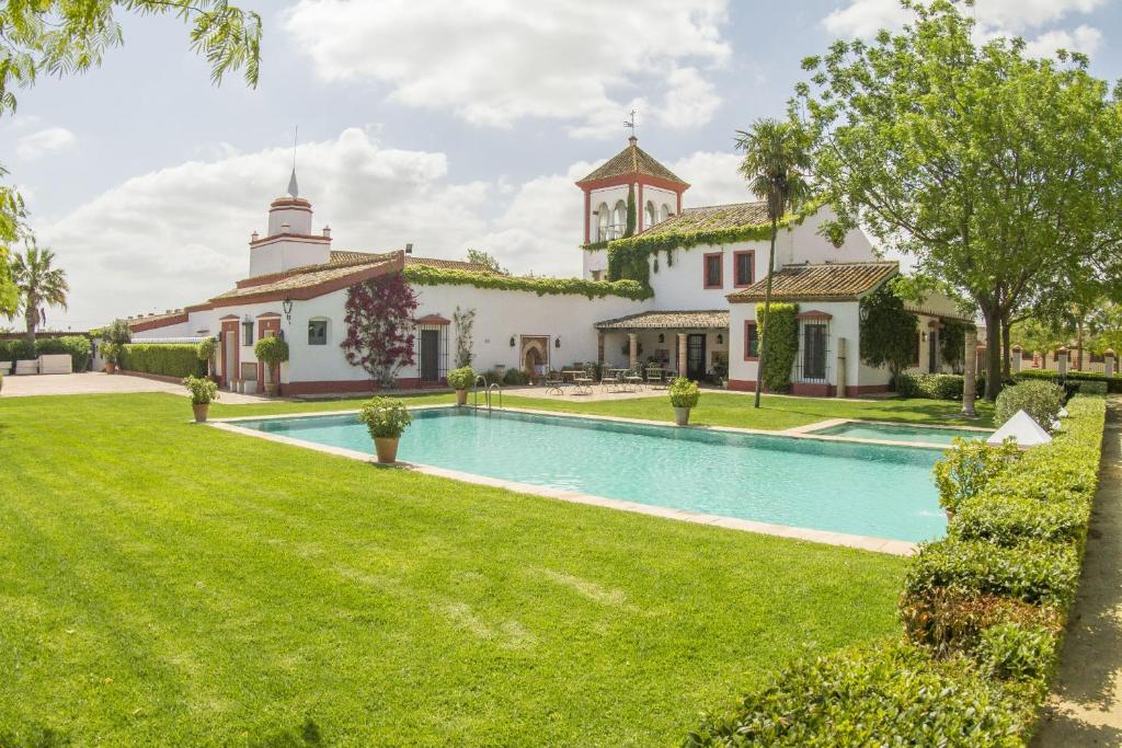 un domaine avec une piscine et un bâtiment dans l'établissement Hacienda de Orán, à Utrera