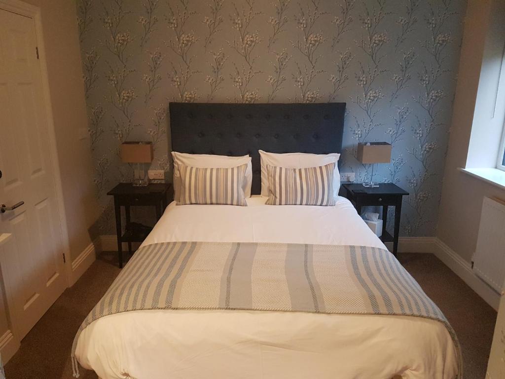 1 dormitorio con 1 cama grande y 2 mesitas de noche en Hendford Apartments, en Yeovil