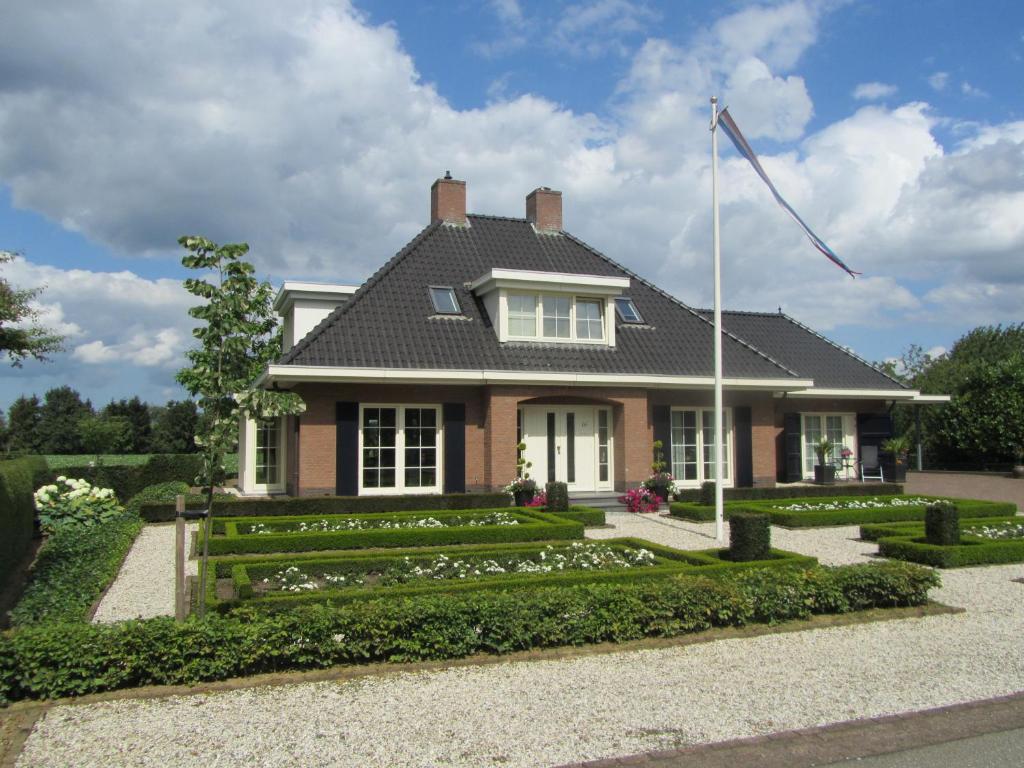een huis met een tuin ervoor bij B&B De Rozenhorst in Baarlo