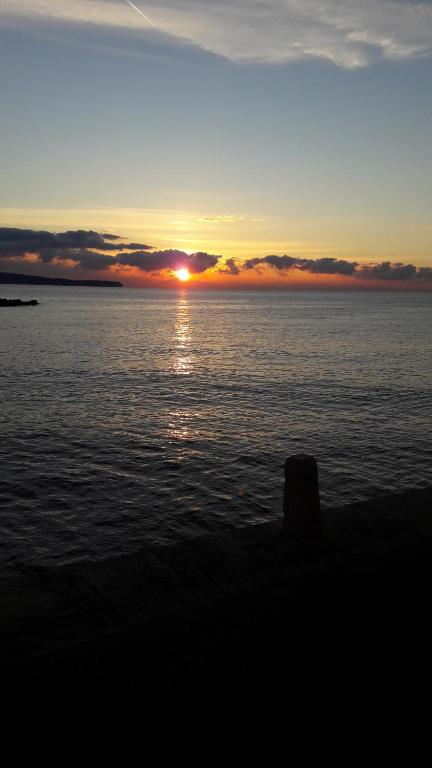 a sunset over a large body of water at Apartman Pavao Fadić in Komiža