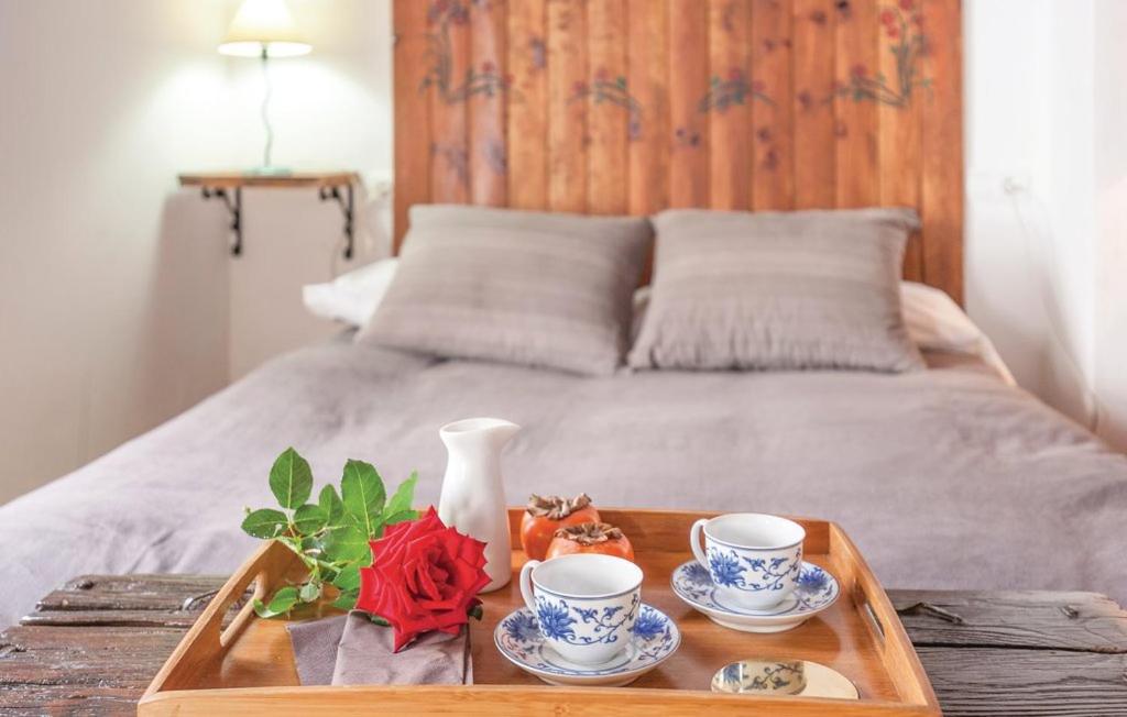 a tray with two cups and a vase on a bed at Casa Rural Sierra de Huelva in Aroche