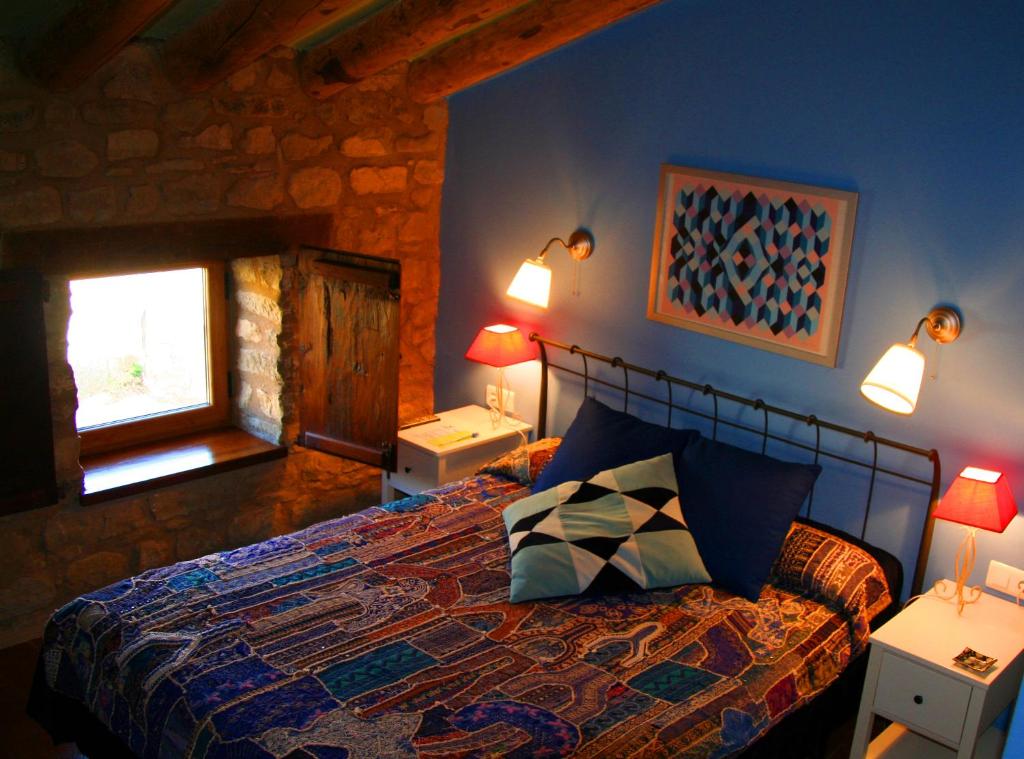 a bedroom with a bed and two lamps and a window at El Corral De Concilio in Concilio