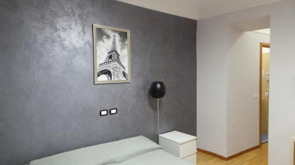 um quarto com uma cama e uma fotografia da Torre Eiffel em Richbaby em Roma