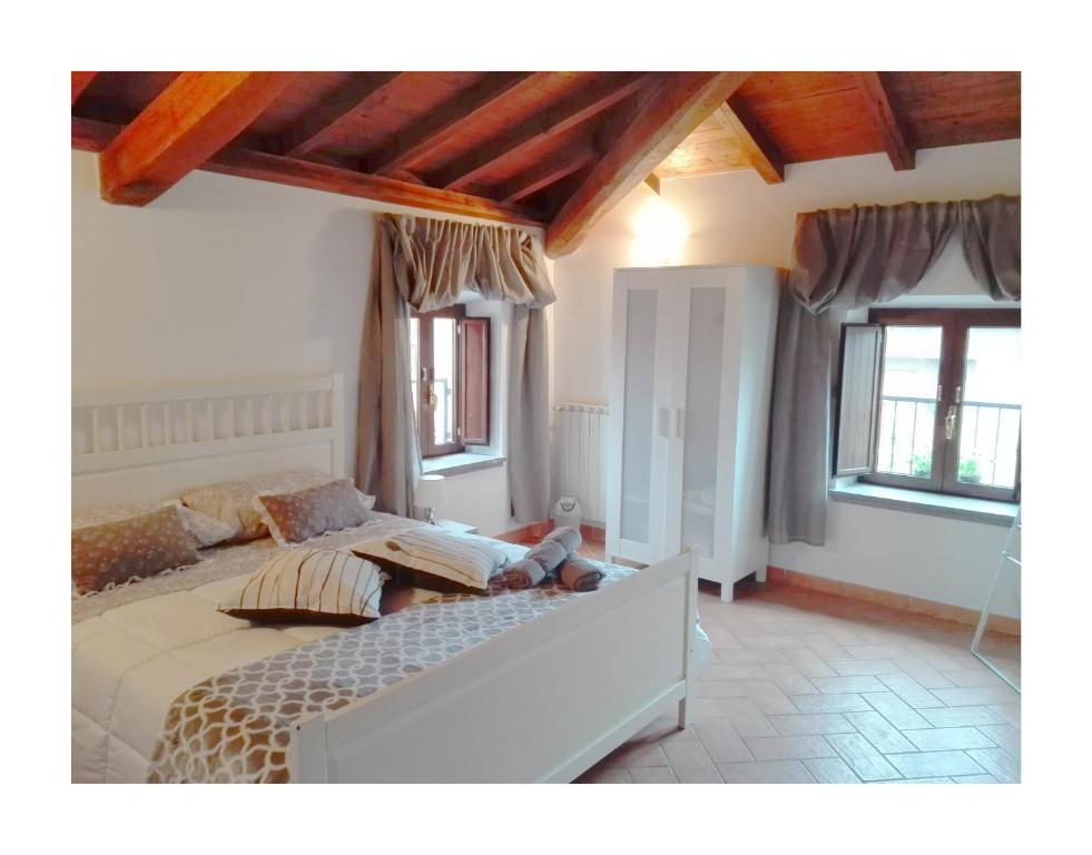 フォルメッロにあるIl Palazzetto sulla Francigenaのベッドルーム1室(大型ベッド1台、窓2つ付)