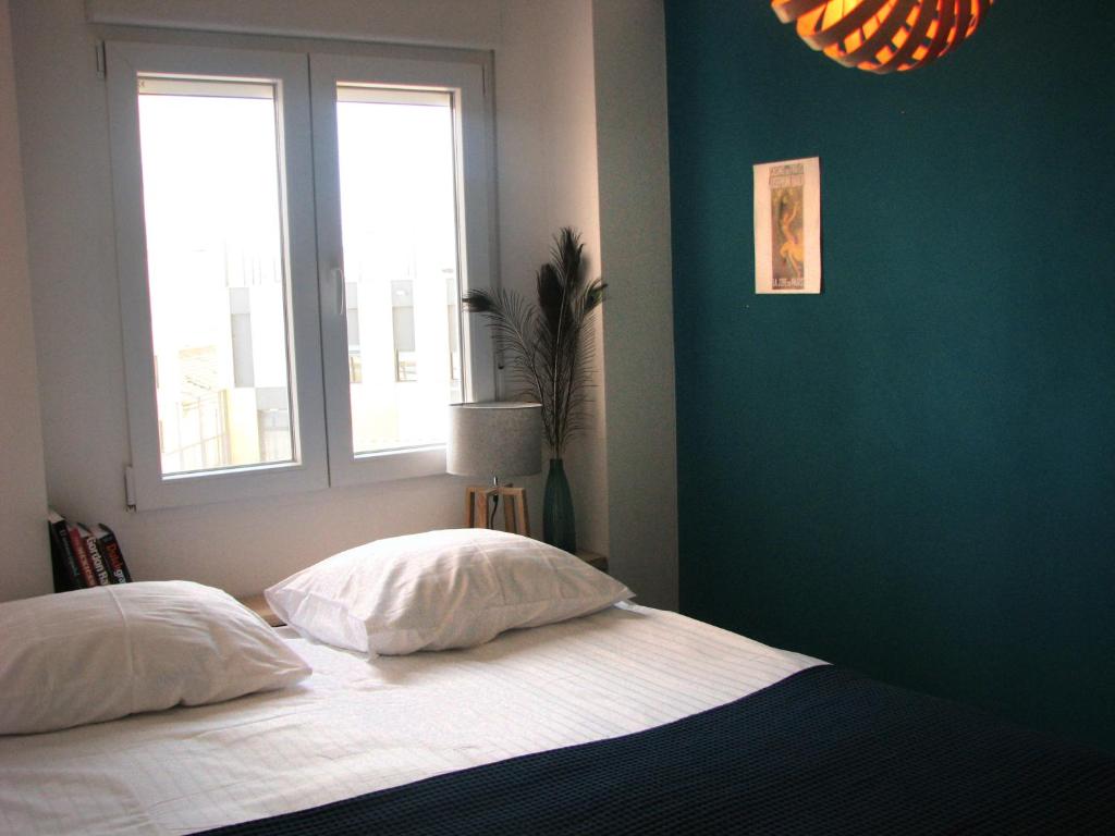 Un dormitorio con una cama con dos almohadas y una ventana. en Alicante Ocean View, en Alicante