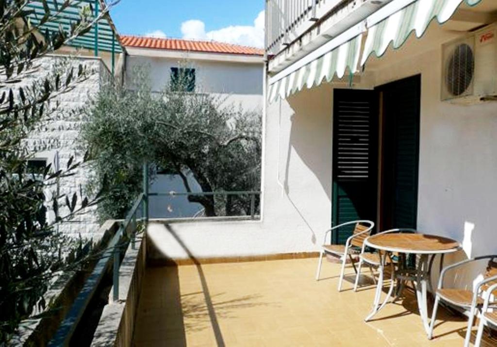patio con mesa y sillas en el balcón en Apartments Maslina, en Sveti Stefan