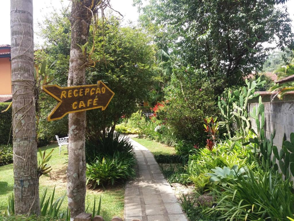 a sign for a backyard cafe on a tree at Pousada Arte de Viver in Lumiar