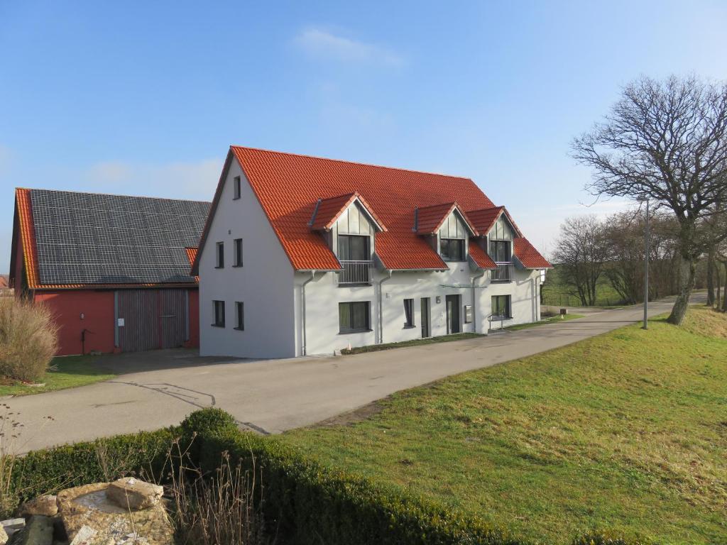 una casa blanca con techo naranja en Ferienwohnung I en Schnelldorf