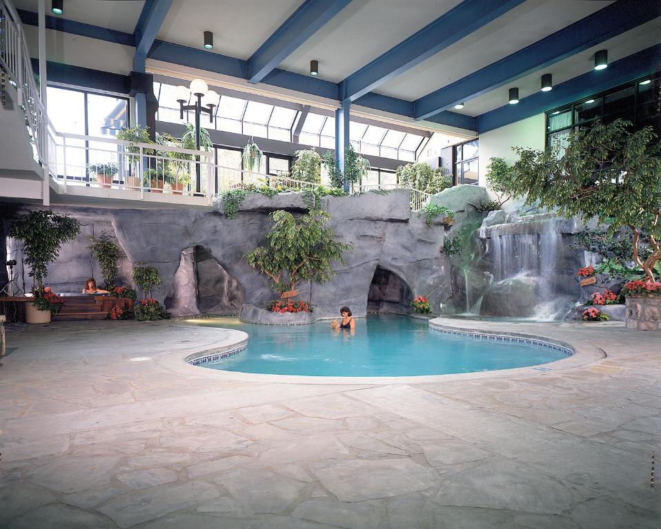 a person in a swimming pool with a waterfall at Sidney James Mountain Lodge in Gatlinburg