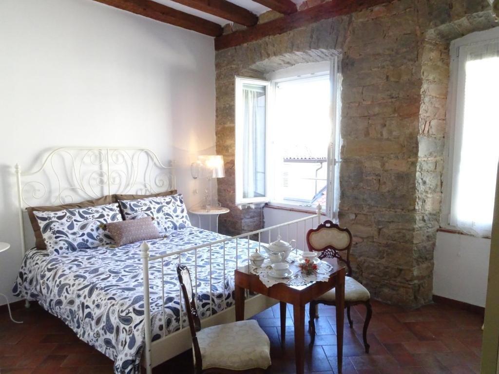 um quarto com uma cama, uma mesa e cadeiras em B&B Gens Julia em Trieste