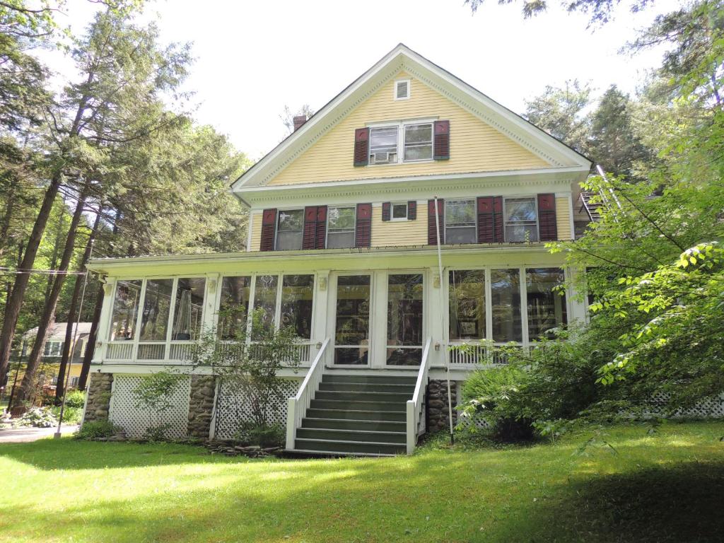 een groot huis met een veranda met glas bij Brookview Manor Inn in Canadensis