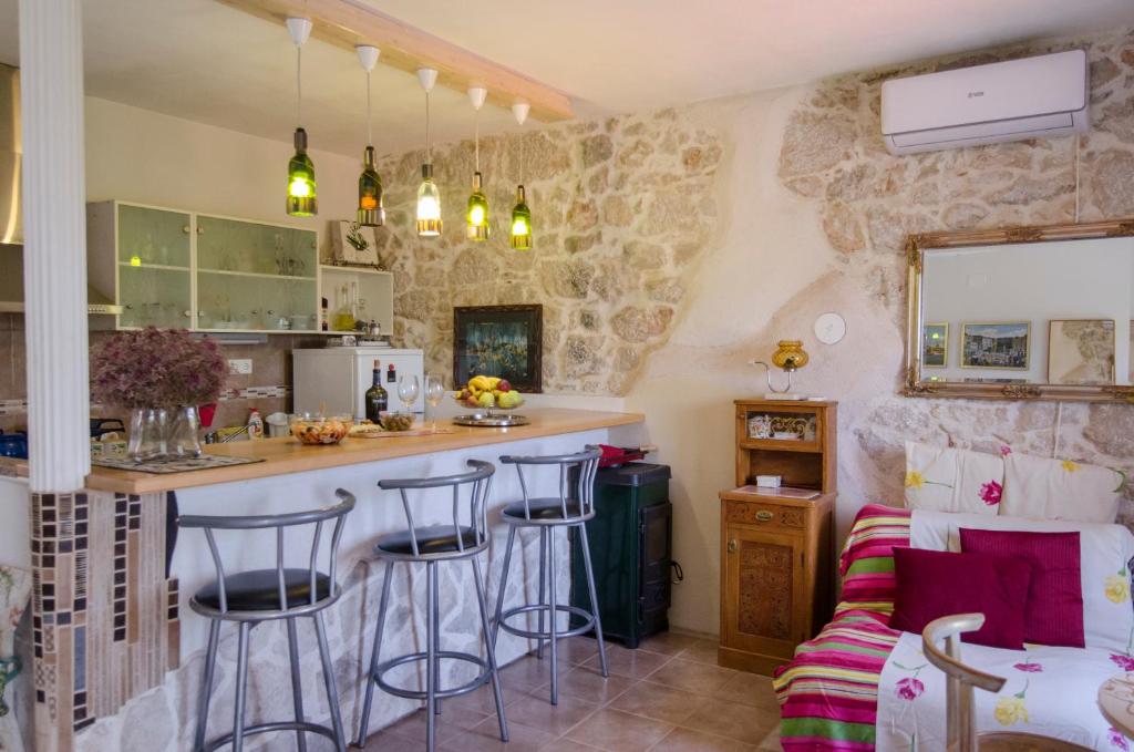 - une cuisine avec un bar et quelques tabourets dans la pièce dans l'établissement Apartments Lavanda & Divona Šibenik, à Šibenik