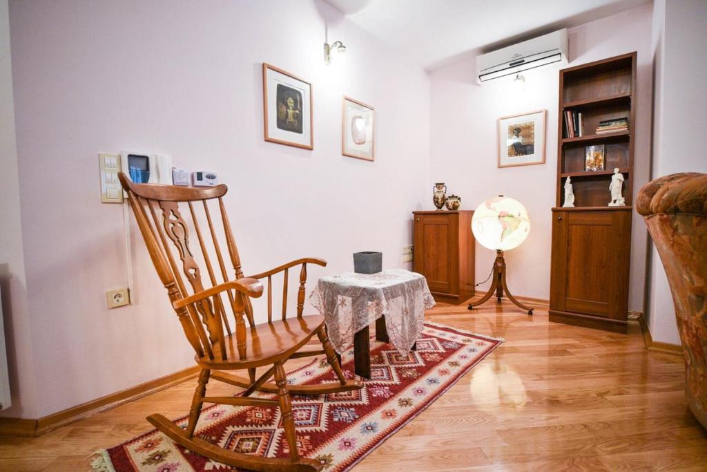 uma sala de estar com uma cadeira de baloiço e uma mesa em Apartman Natalija Banja Luka em Banja Luka