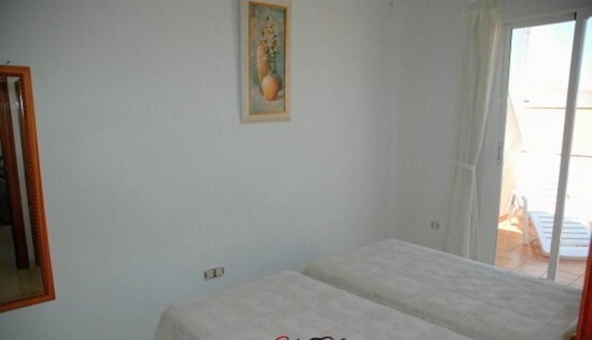 sypialnia z 2 łóżkami i zdjęciem na ścianie w obiekcie One-bedroom flat 200m from the beach w mieście Almería