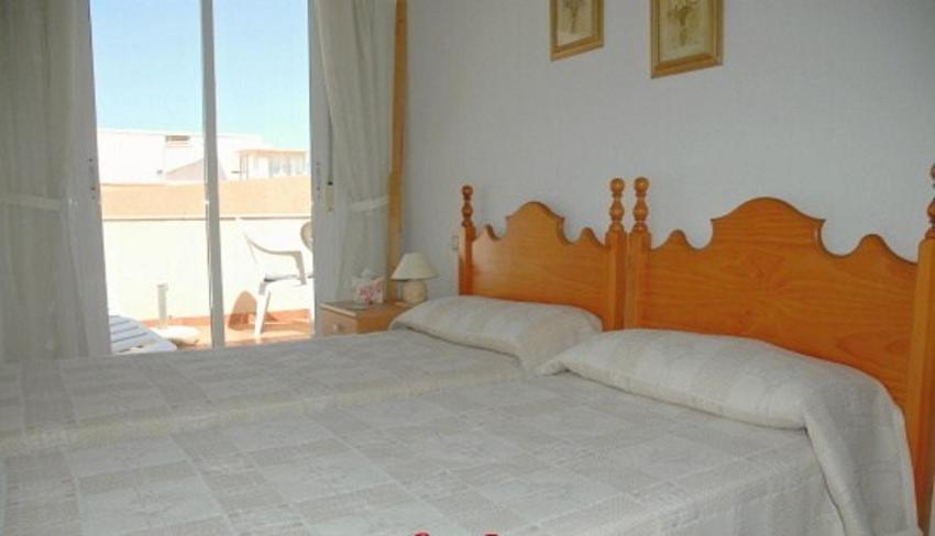 sypialnia z dużym łóżkiem i dużym oknem w obiekcie One-bedroom flat 200m from the beach w mieście Almería