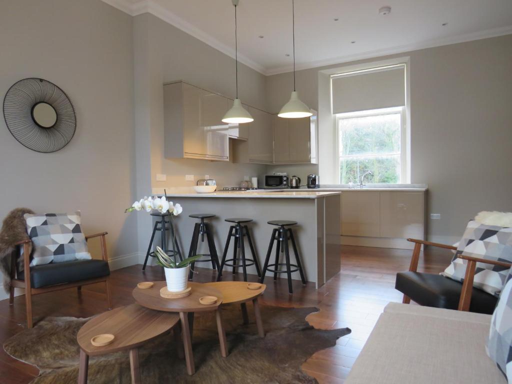 uma cozinha e sala de estar com mesa e cadeiras em Barclay House em Kelso