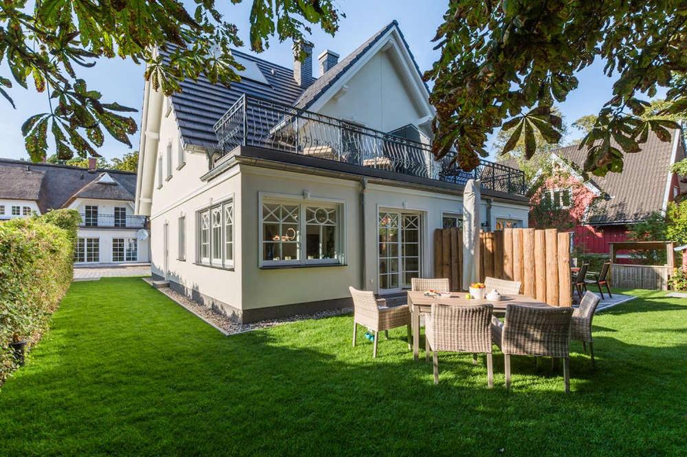 a house with a yard with a table and chairs at Ferienhaus Ostseehaus Seegras mit Kamin in Prerow