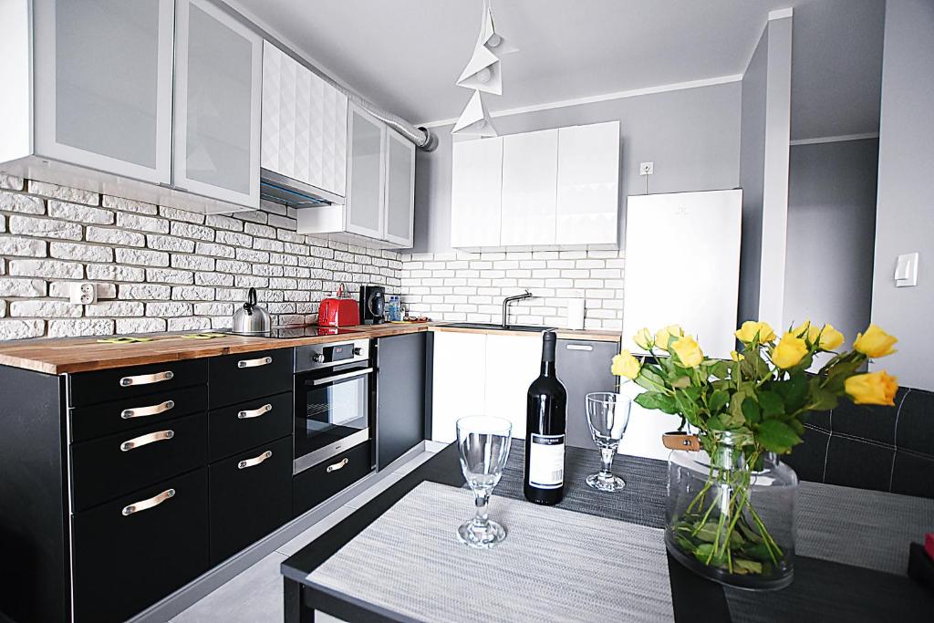 una cucina con tavolo, bicchieri da vino e fiori di DesignOmania Apartments - Przedwiośnie 2A a Cracovia