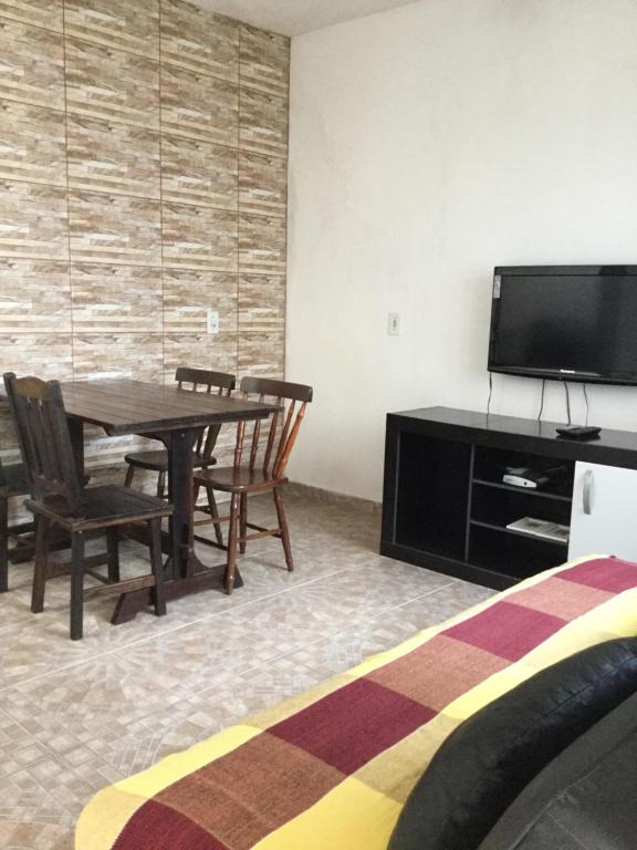 Habitación con mesa, sillas y TV de pantalla plana. en Venha para Florianópolis, en Florianópolis