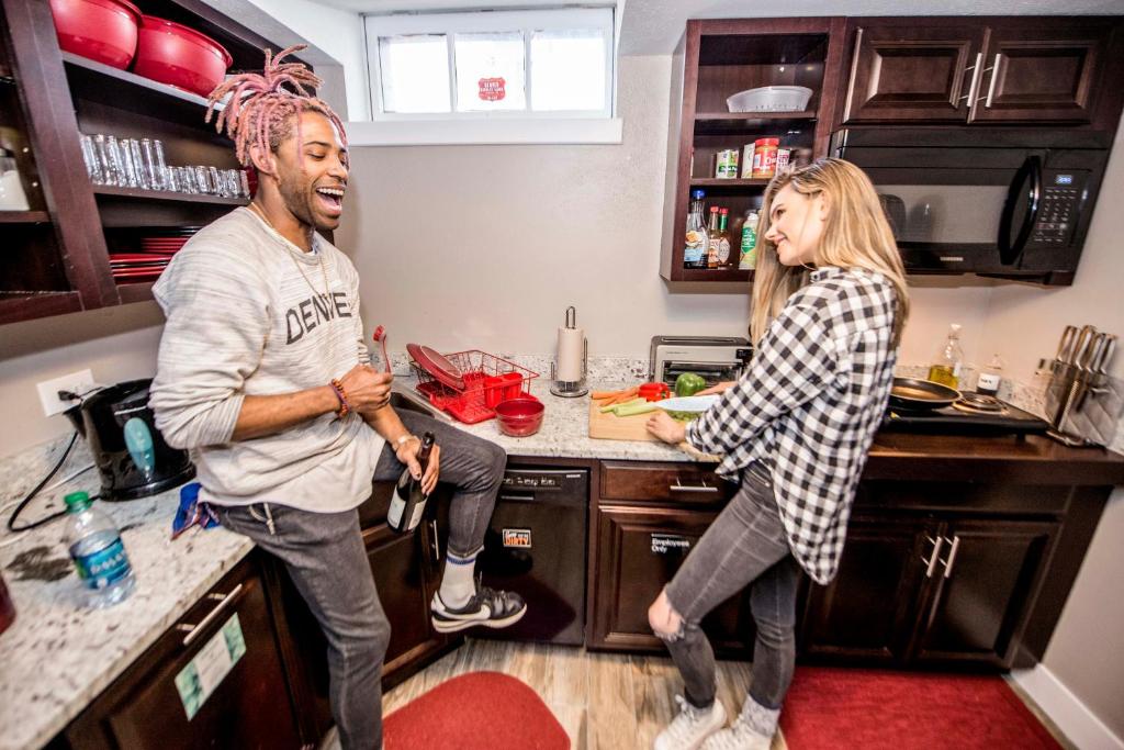 a man and a woman standing in a kitchen at Ember Hostel in Denver