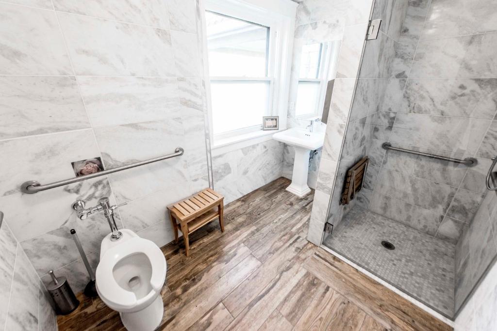 a bathroom with a toilet and a shower and a sink at Ember Hostel in Denver