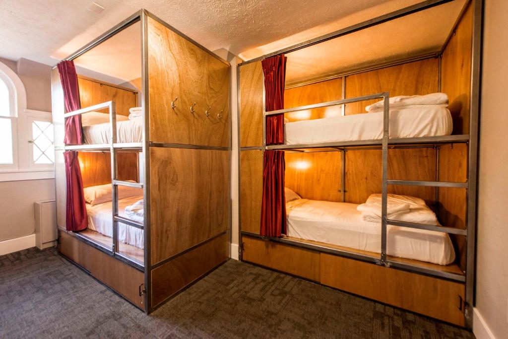 a room with three bunk beds in a room at Ember Hostel in Denver