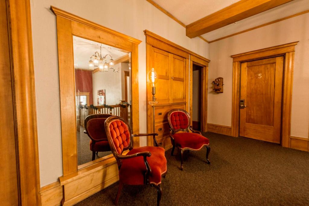 a living room with two chairs and a mirror at Ember Hostel in Denver