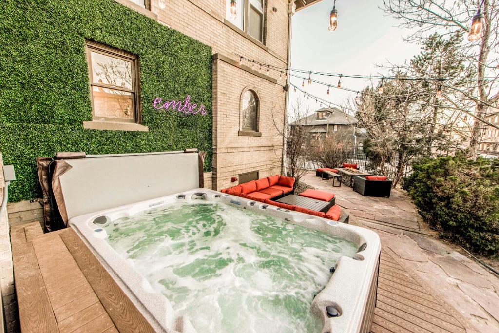 a jacuzzi tub on a patio next to a building at Ember Hostel in Denver