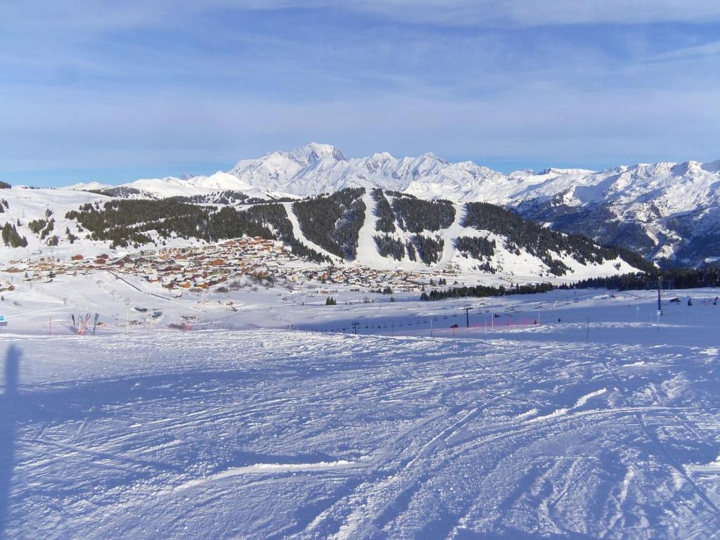 eine Skipiste mit schneebedeckten Bergen im Hintergrund in der Unterkunft Petit HAUTLIEU in Les Saisies