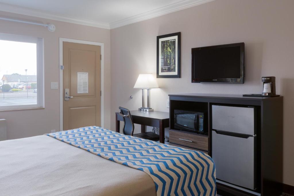 a hotel room with a bed and a flat screen tv at Travelodge by Wyndham Eureka in Eureka
