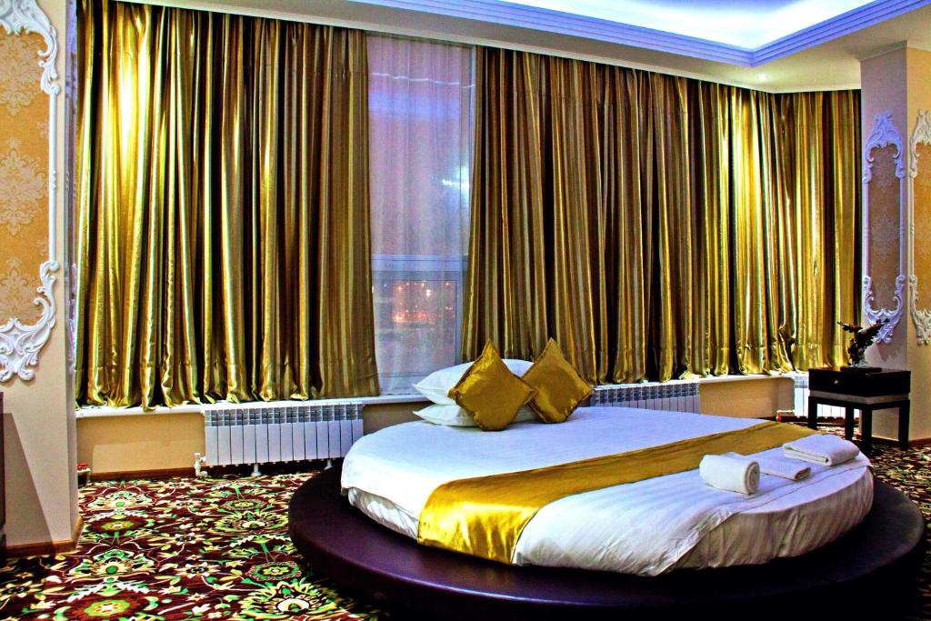 a bedroom with a large bed in front of a window at Sky Luxe Hotel in Astana