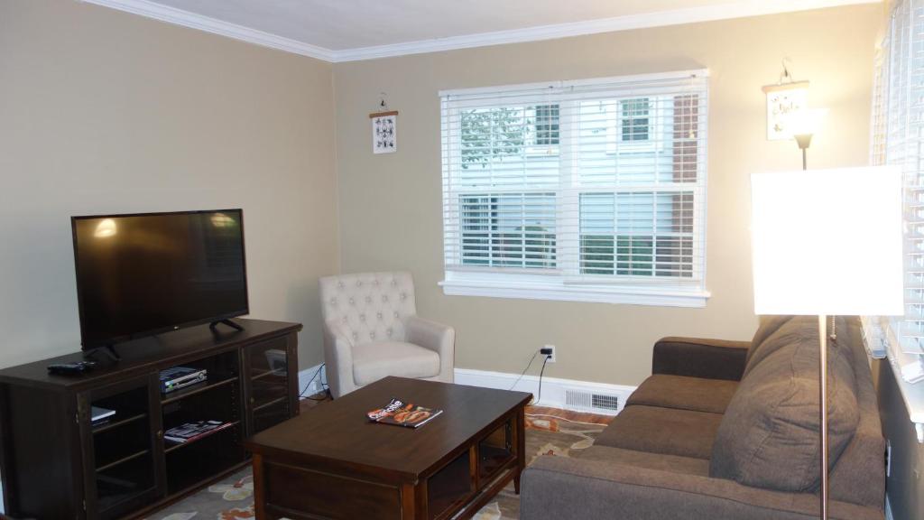 a living room with a couch and a flat screen tv at The Right Side Duplex in Charlotte