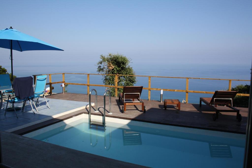 einen Pool mit Stühlen und einem Sonnenschirm in der Unterkunft Villa Alice in Santo Stefano di Camastra