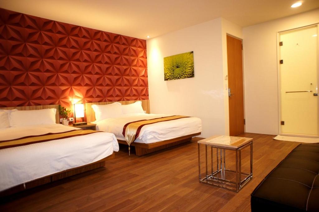 Habitación de hotel con 2 camas y sofá en Simonhall B&B en Tainan