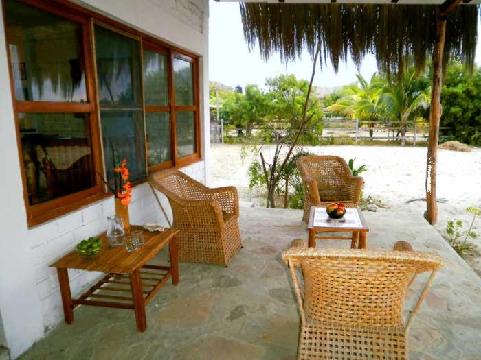 a patio with wicker chairs and a table and a tableablish at Villa Belluno in Zorritos