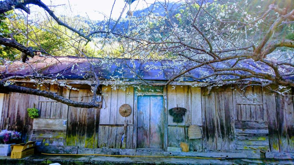 an old wooden house with a blue door at Bestime B&amp;B in Jiji