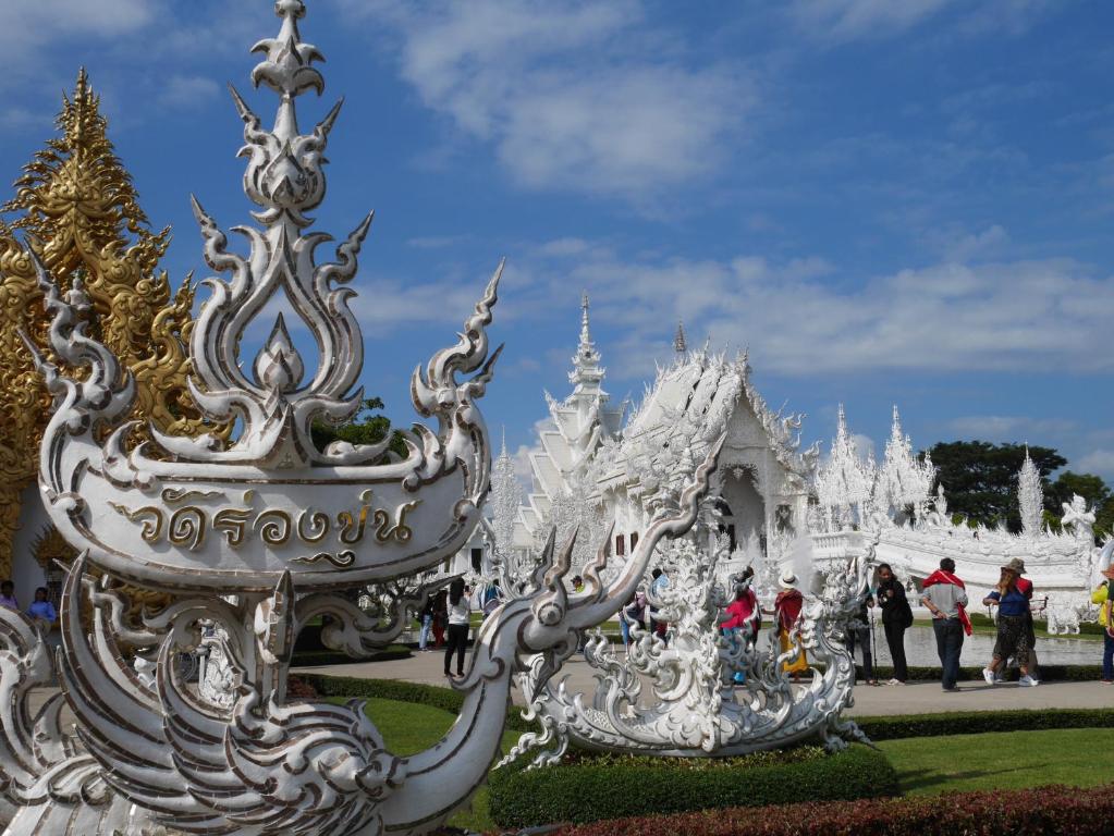 Un groupe de personnes debout devant un temple blanc dans l'établissement Latisha House, à Chiang Rai
