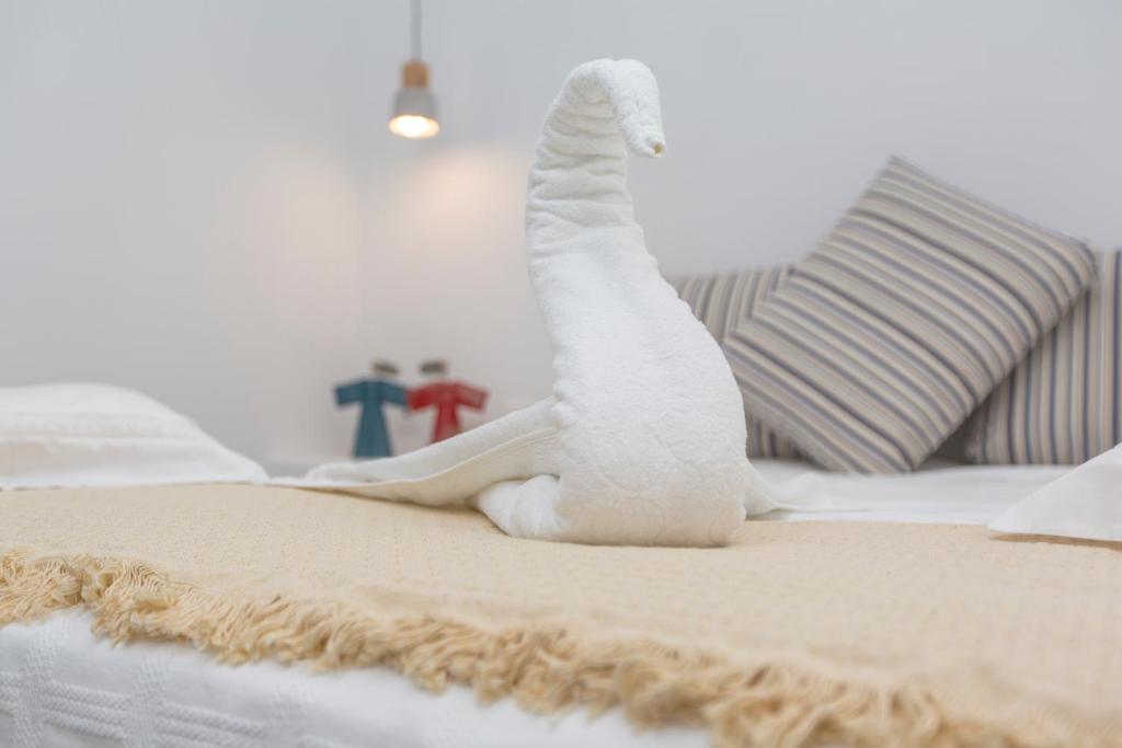 um bicho de peluche branco está sentado numa cama em Eudaimonia em Naxos Chora