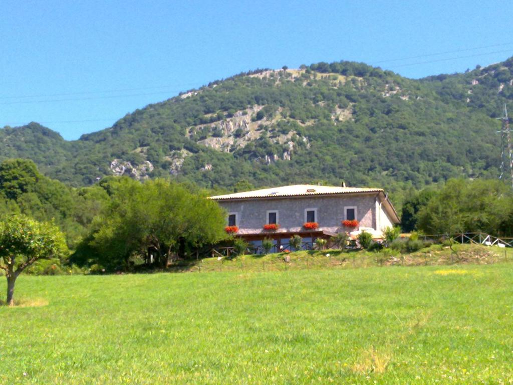 a house in a field in front of a mountain at La Poiana in Barrea