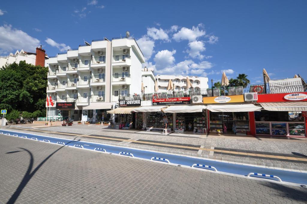 a large white building on a street in front of a building at Reis Maris Hotel in Marmaris