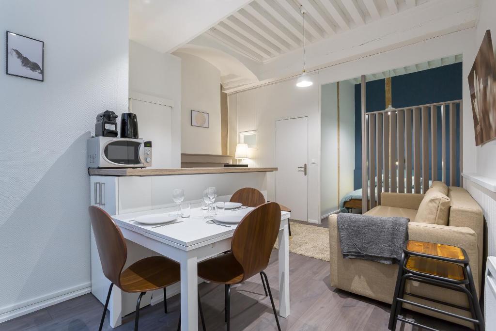 Il comprend une cuisine et un salon avec une table et des chaises. dans l'établissement Jusquà 6 personnes au coeur du Vieux Lyon, à Lyon