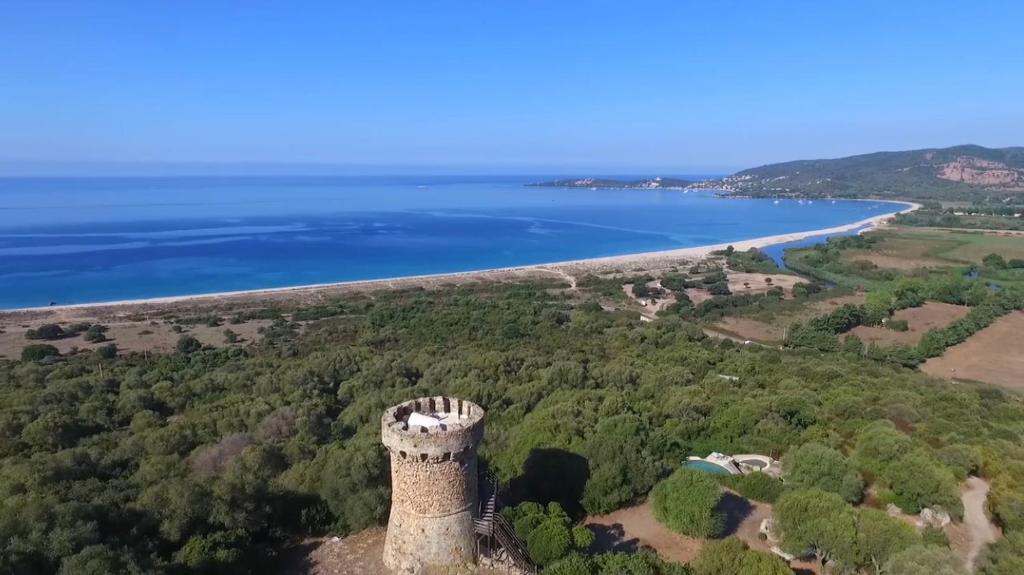 an aerial view of a castle next to a body of water at Tour Génoise Micalona, Domaine de l'Oglisatru in Olmeto