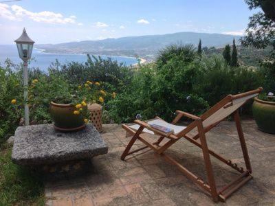 a chair sitting on a patio with a view of the ocean at Cottage Torre Elena - Staletti in Stalettì