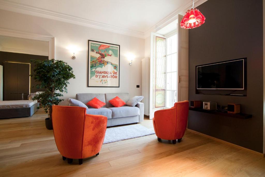 sala de estar con sofá y sillas de color naranja en Luxury Flat Riberi sotto la Mole, en Turín